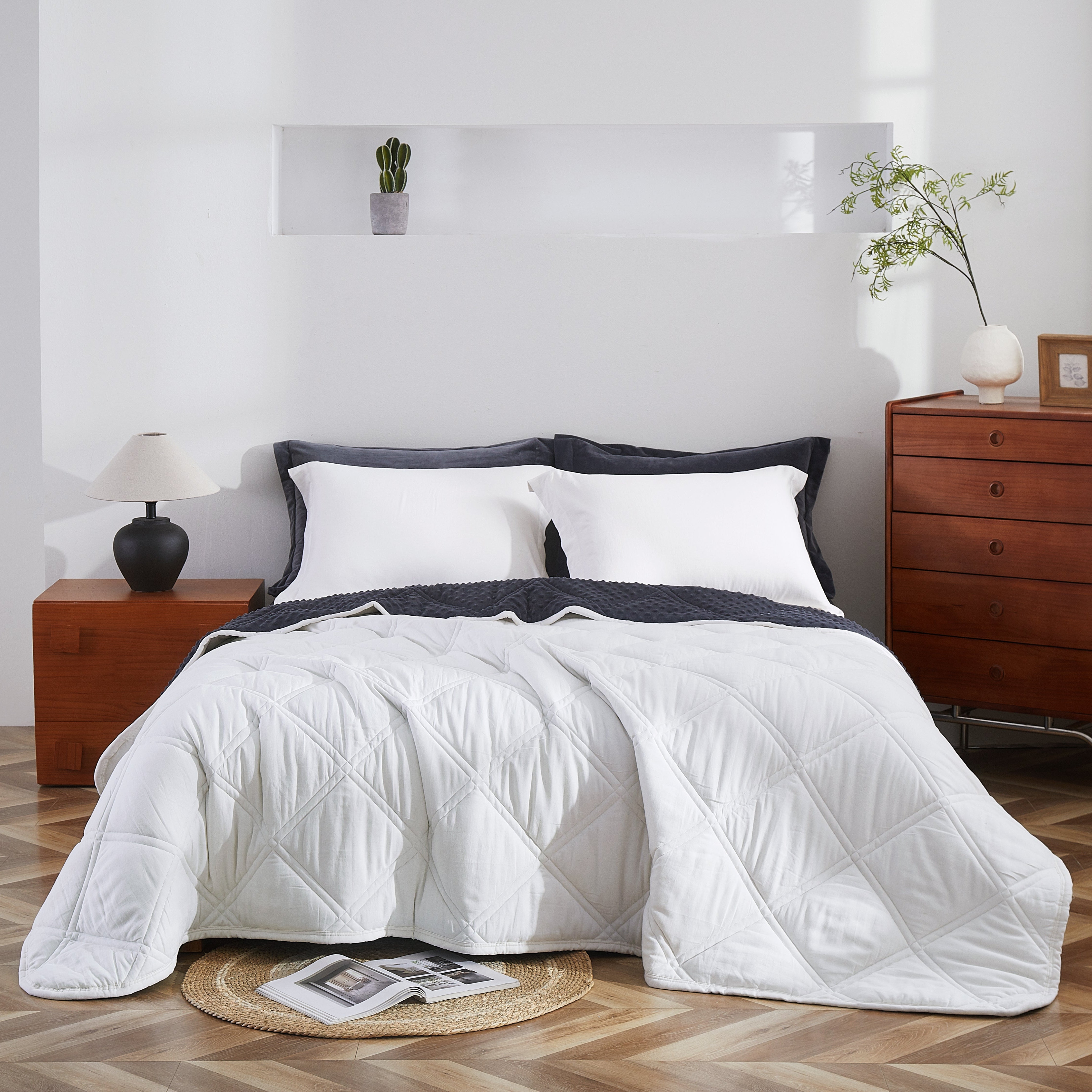 White comforter on a bed in a bedroom with wooden nightstands and decor.
