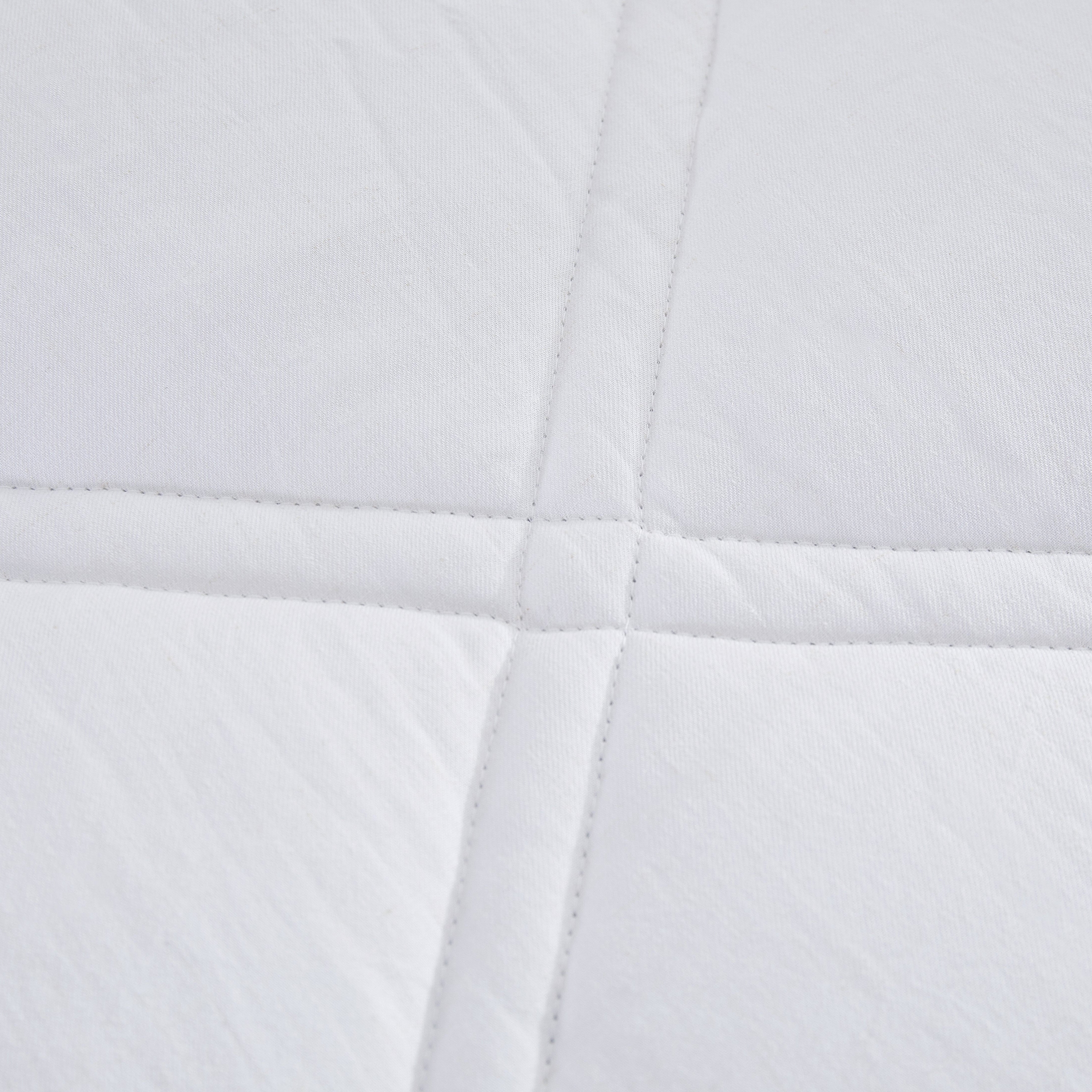 Close-up of a white quilted fabric with a diamond pattern