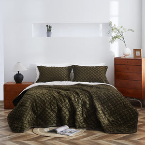 Bedroom with a bed covered in green quilt and pillows, wooden nightstands, and a lamp.