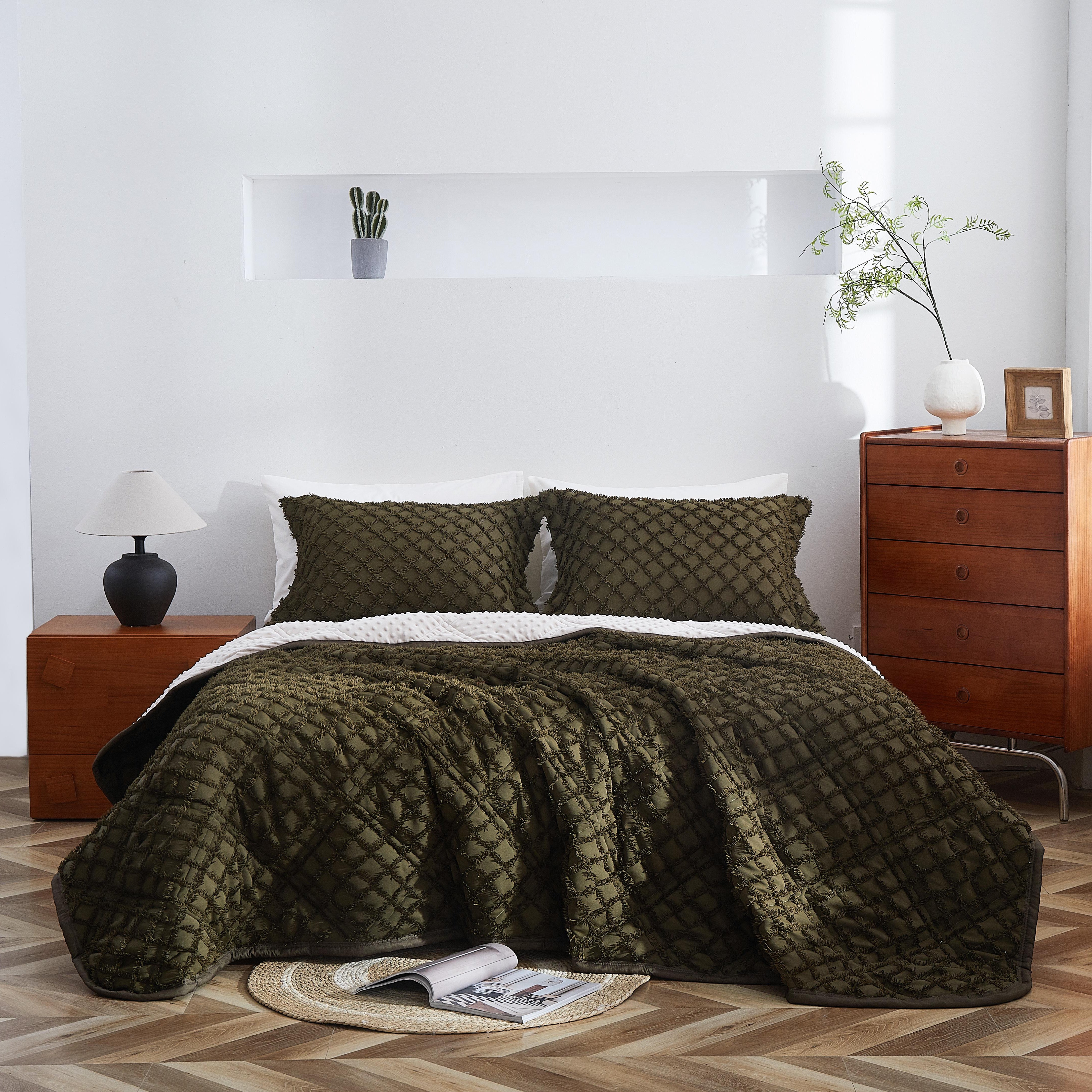 Bedroom with a bed covered in green quilt and pillows, wooden nightstands, and a lamp.