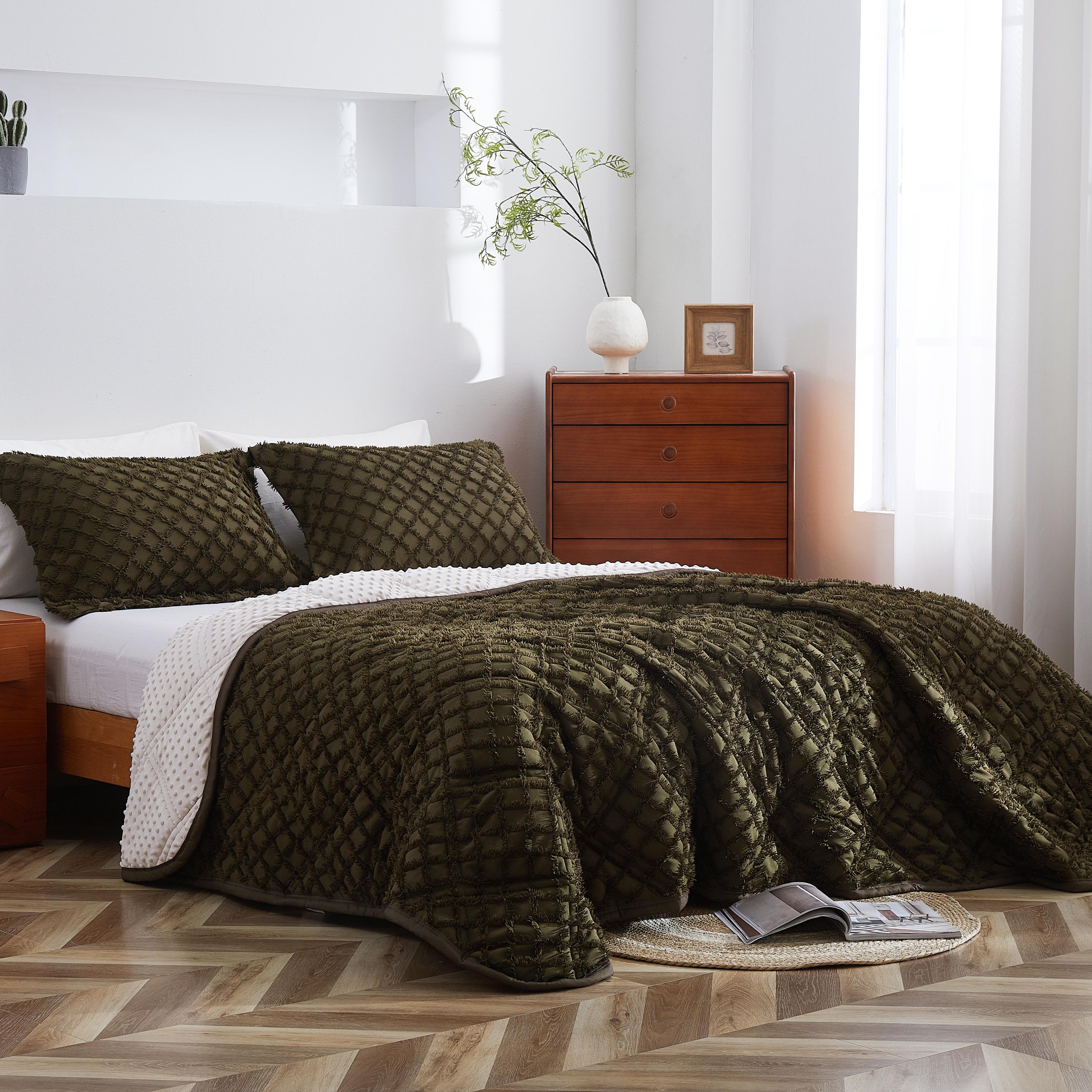 Bedroom with a bed covered in a green quilt, wooden nightstands, and a lamp.