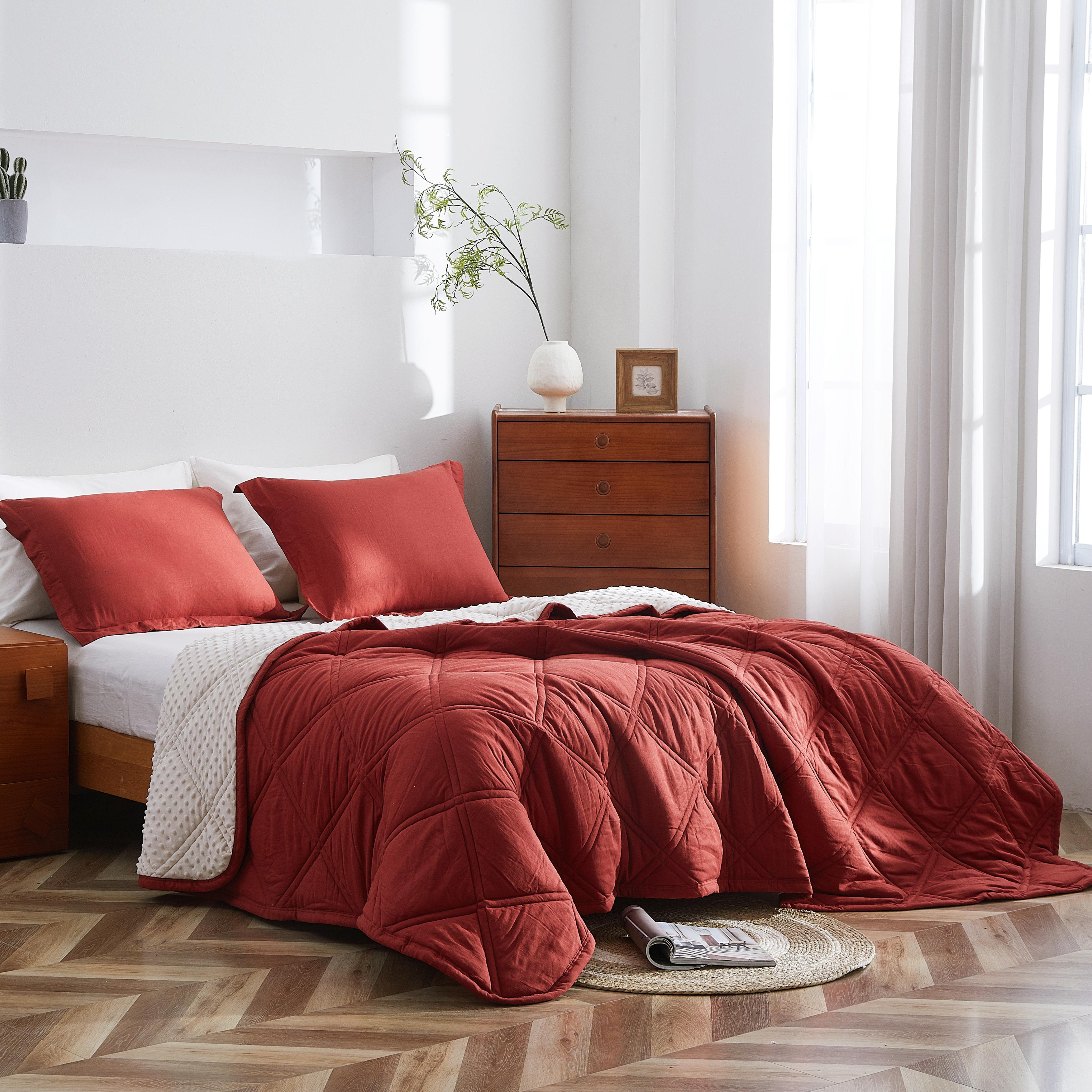 Bedroom with red bedding and wooden furniture