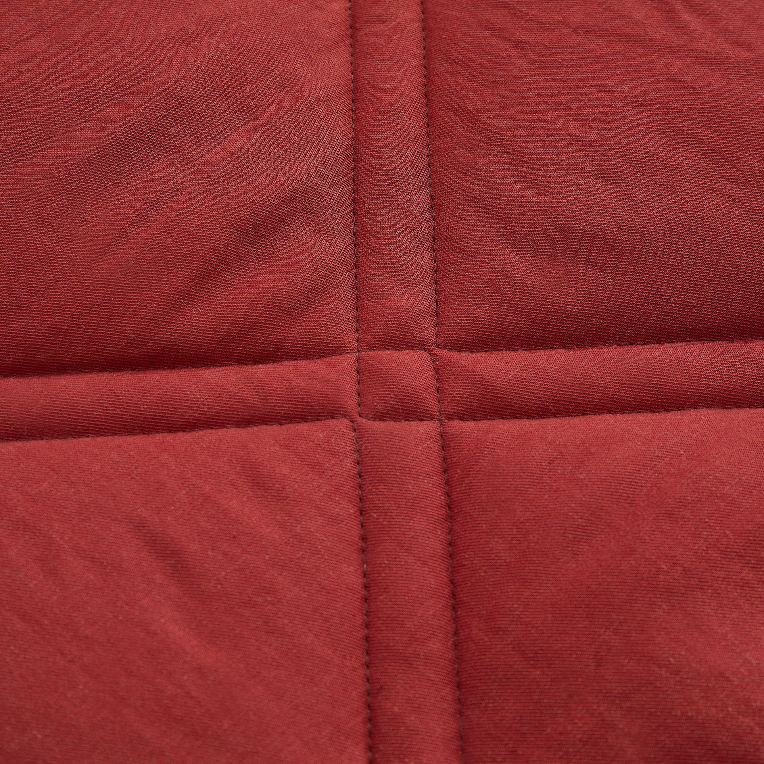 Close-up of red fabric with a quilted pattern