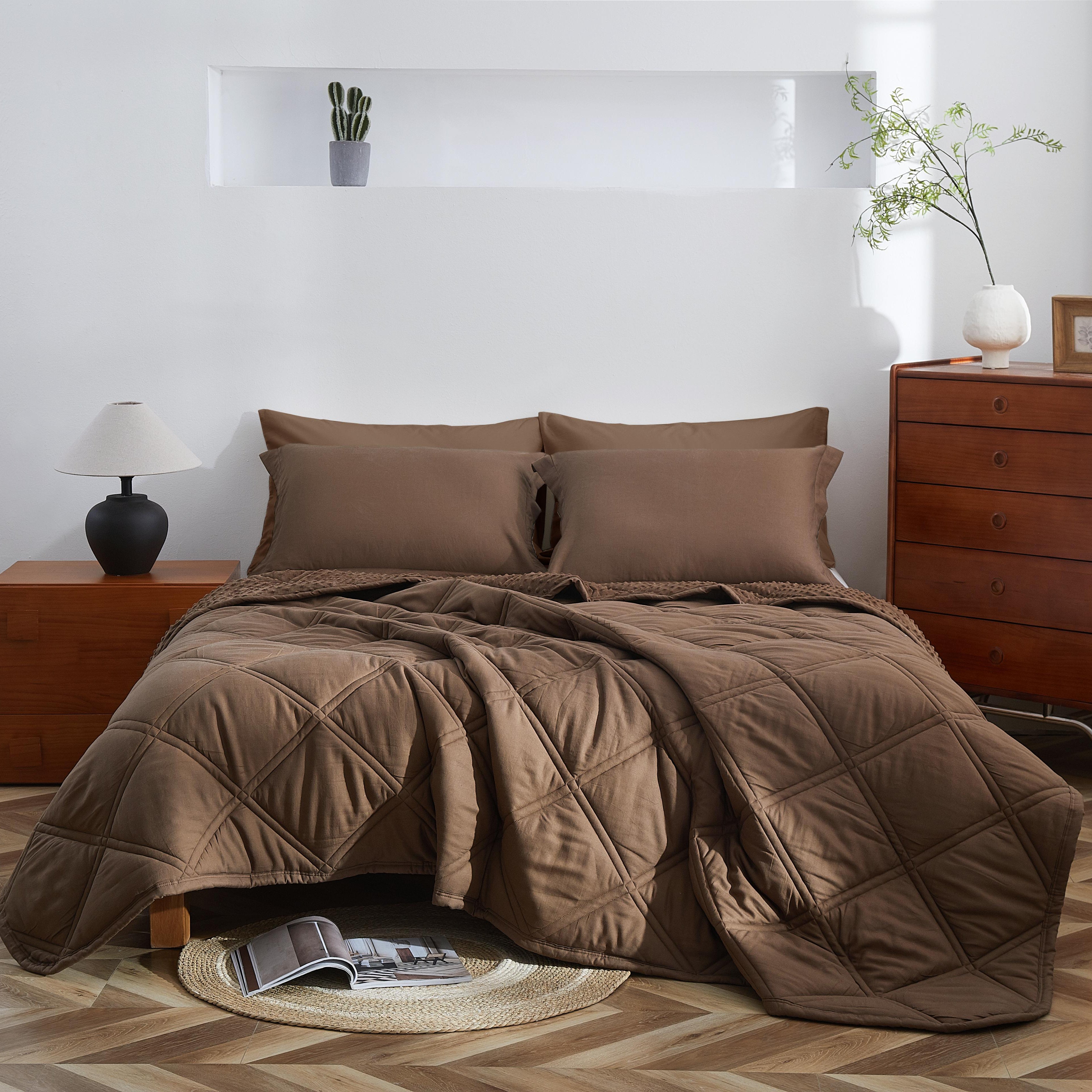 Brown quilted comforter on a bed in a bedroom with wooden furniture.