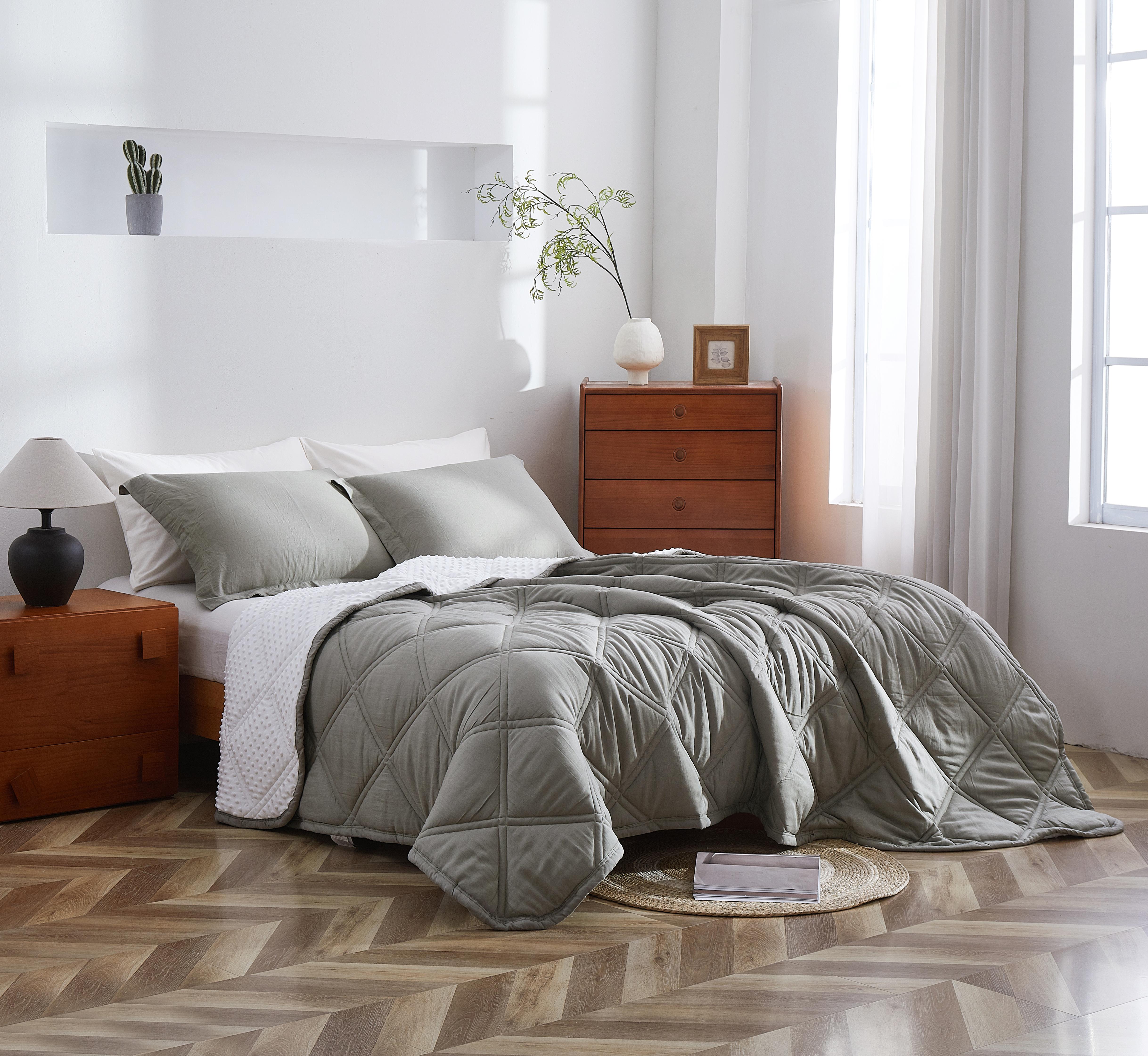 Bedroom with a neatly made bed featuring a gray comforter and pillows.