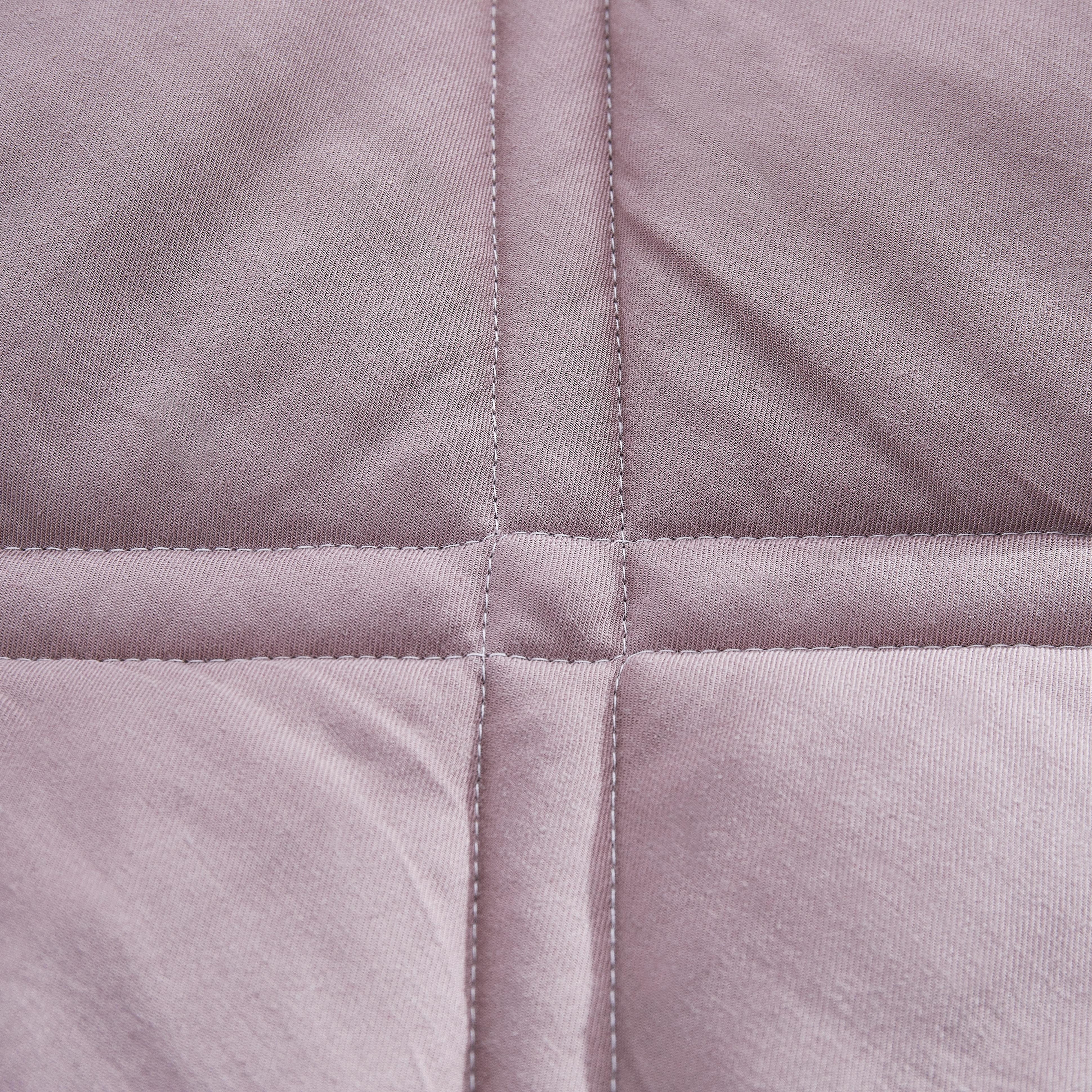 Close-up of a quilted pink fabric with diamond pattern